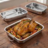 Three stainless steel roasting trays displayed on wood, one filled with roasted chicken and vegetables.