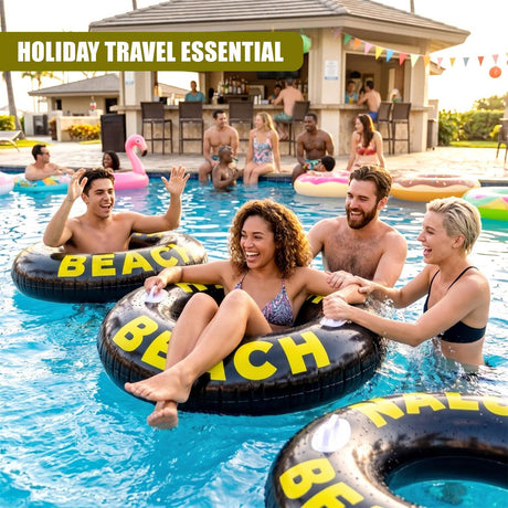 Black inflatable tire rings with yellow lettering float in bright blue pool water.