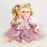 A small doll dressed in a pink dress.