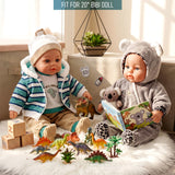 Two dolls sit with toys, blocks, and a book, surrounded by miniature plastic dinosaurs and accessories.