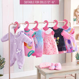 Six hanging doll clothes are displayed on a rack, accompanied by pink doll shoes and accessories.