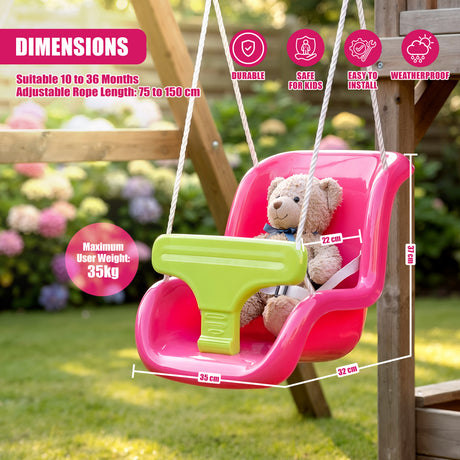 A pink toddler swing seat with a green safety bar, featuring a teddy bear inside, hanging from ropes on a wooden frame in a