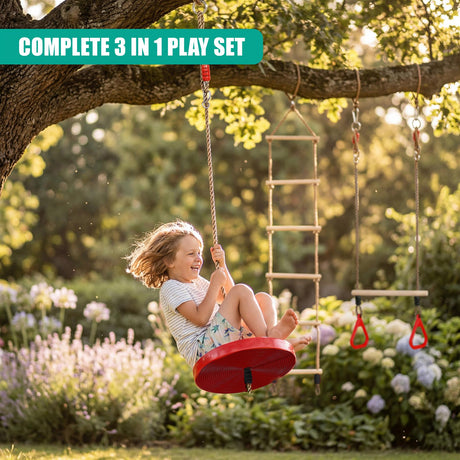 A child swings in a red seat from a tree branch near a ladder and hanging trapeze set.