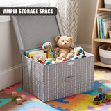 A gray fabric storage box with a heart pattern, filled with toys including a teddy bear and books, sits on a colorful play