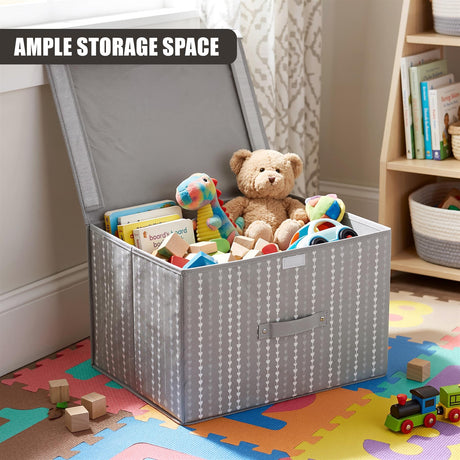 A gray fabric storage box with a heart pattern, filled with toys including a teddy bear and books, sits on a colorful play