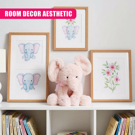 A collection of framed prints featuring a blue elephant with pink ears and a pink flower, displayed on a white wall with a plush pink elephant in the foreground. - UKBuyZone