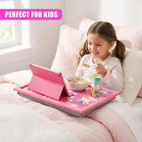 Girl uses a pink lap tray holding a tablet, cereal bowl, and snack items on a bed.