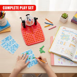 Hands play with a red bingo lotto board, blue cards, and writing tools on a table.