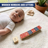Wooden blocks spelling "MONTHS" and an individual number six block displayed on a white mat.
