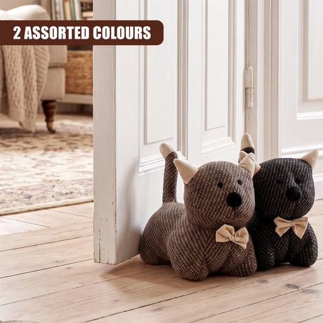 Two stuffed, woven dog door stoppers, one tan and one dark grey, resting by a white door.