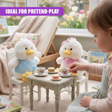 Two plush chicks and a small tea set are arranged on a child-sized wooden table.