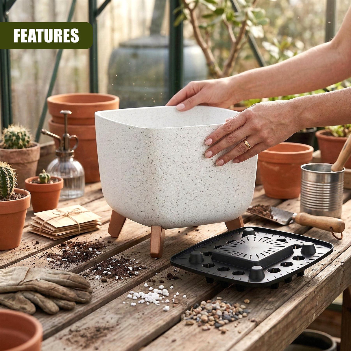 Ceramic plant pot on legs and a matching drainage tray sit on weathered wood surfaces.