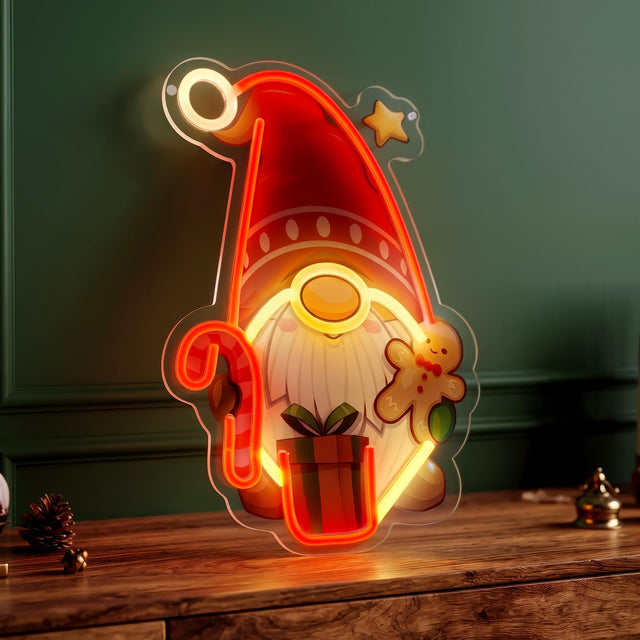 A red and yellow neon light sign shaped like a Santa gnome wearing a hat, holding a candy cane and gingerbread man, standing