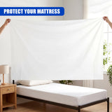 White waterproof bed cover draped over a bed frame, featuring text overlays on the image.