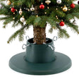 An adjustable green Christmas tree stand holding a decorated real tree