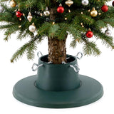 An adjustable green Christmas tree stand holding a decorated real tree