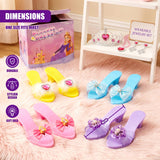 Several colorful pairs of princess play shoes are arranged near a pink box and jewelry set.