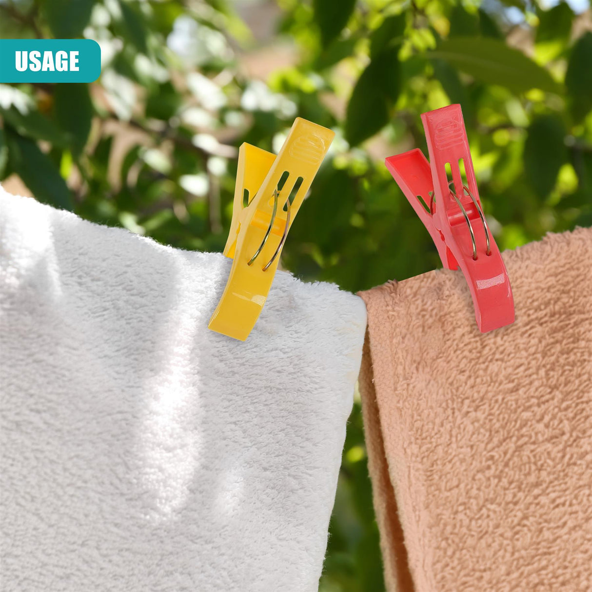 Three colorful clips hold white and tan towels against a lush green outdoor background.