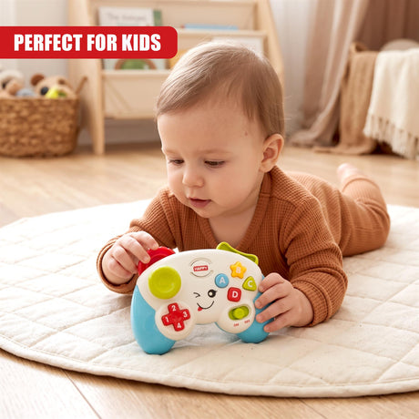 A baby wearing a brown outfit lies on a white mat playing with a blue and white game controller toy featuring buttons and