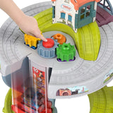 Child's hand places colored connector piece onto a train track on the play table.
