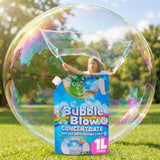 A large iridescent soap bubble reflects a woman and a blue and green liquid container labeled Bubble Blow Concentrate.