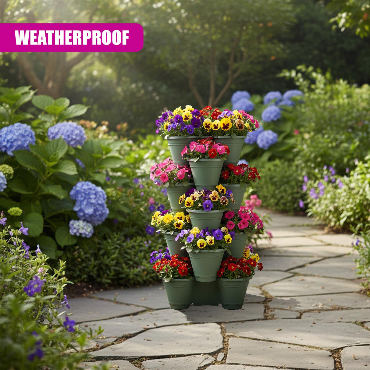 Brightly colored potted flowers stacked vertically sit on a stone patio surrounded by hydrangeas.