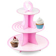 Three-tiered pink cardboard stand featuring footprint, stripe, and dot patterns, displaying three sample cupcakes.