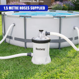 An above-ground pool setup with a white filter pump and attached hoses.