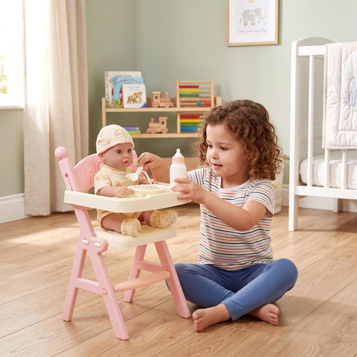 Girl feeding a baby doll at a pink doll high chair set with accessories.