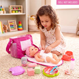 A girl interacts with a doll and accessories kit, including a pink changing pad and bag.