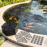 Multiple metal pond grate sections float on water and rest on the curved stone edge.