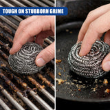 A person uses a metallic scrubber on burnt residue on a grate and a dark cooking surface.
