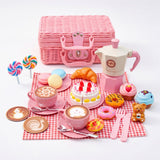 A tea party set including a picnic basket, teapot, teacups, miniature treats, and a teddy bear.