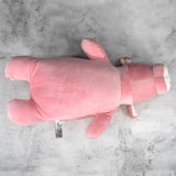 Pink plush pig sitting on gray background.