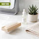 Light wooden block with numerous bristles designed for scrubbing fingernails and cuticles.