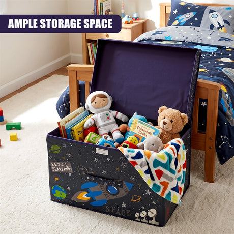 The Magic Toy Shop Blast Off Large Storage Box filled with toys and books, sitting on a carpeted floor next to a bed