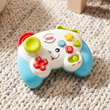 Game controller toy by The Magic Toy Shop, featuring a smiling face, coloured buttons and switches, resting on a knitted rug