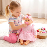 Girl feeds a large baby doll in a pink ruffled outfit; toys rest in a basket nearby.