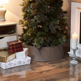 Brown Christmas tree skirt with woven texture under a decorated tree and wrapped gifts on wooden floor