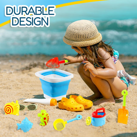 This is an advertisement for a toy beach playset, which includes a foldable bucket, rake, shovel, and various other toys. The set has been placed on a sandy beach near the ocean.