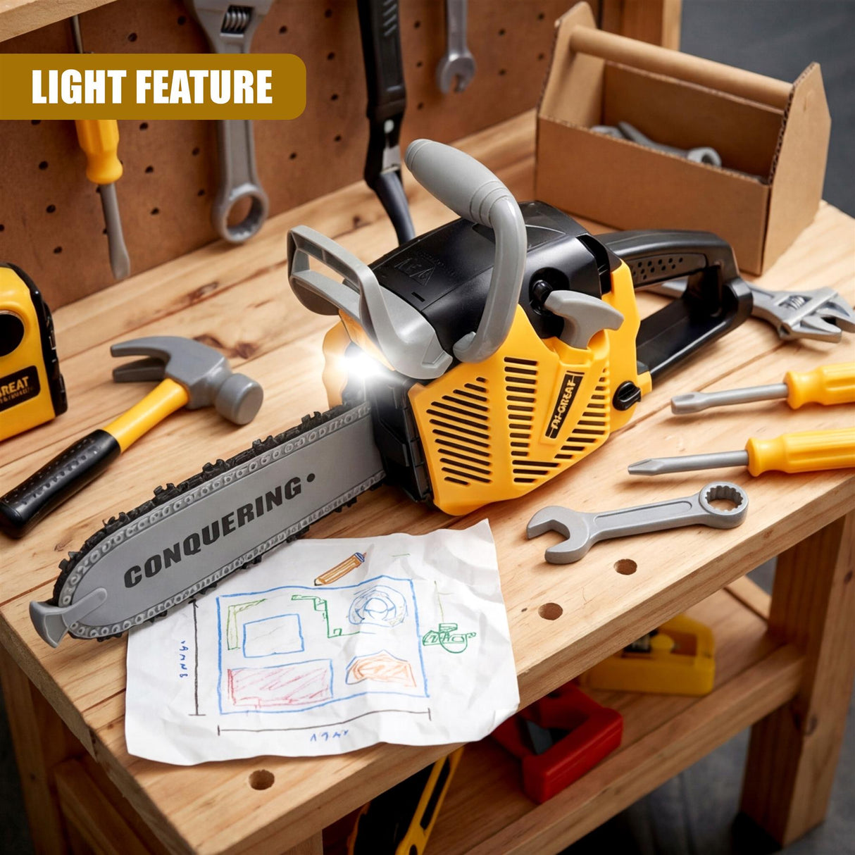 A yellow toy chainsaw and various tools rest on a wooden workbench with a drawing.