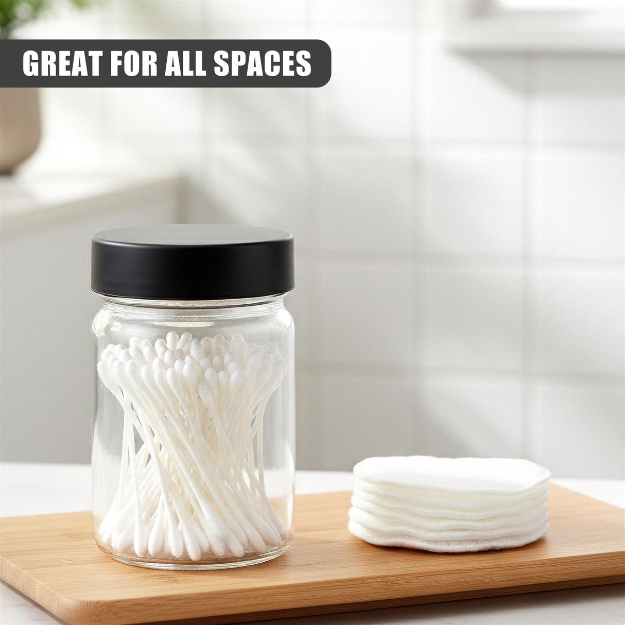 Clear glass jar holding white spice sticks rests near a stack of white round lid components on wood.