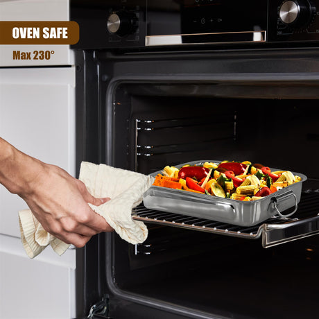 A metal roasting pan holding colorful vegetables rests on an oven rack inside a kitchen oven.