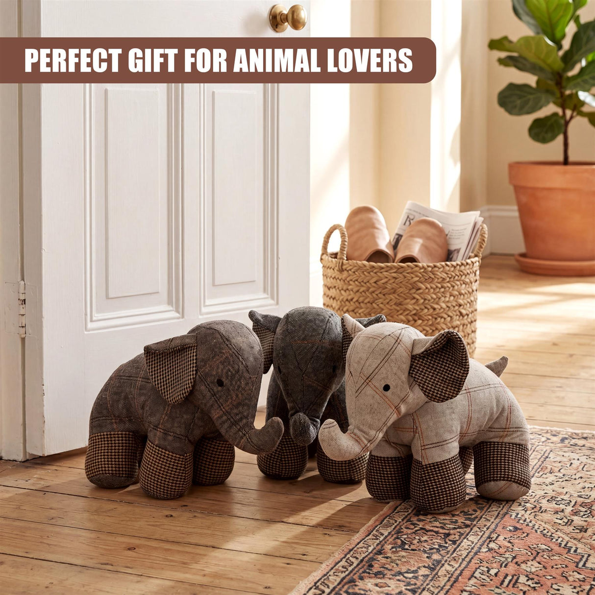 Three tartan patterned stuffed elephant door stoppers rest on a patterned floor rug.
