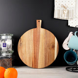 "Two acacia cutting boards with handle and round base, leaning against a black background." - UKBuyZone