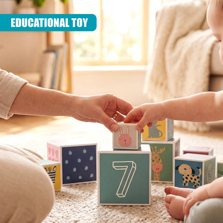Hands stack large wooden blocks displaying numerals, animals, and colorful painted designs.