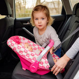 Baby seated in a heart-patterned car seat inside a car; a girl and hand are present.