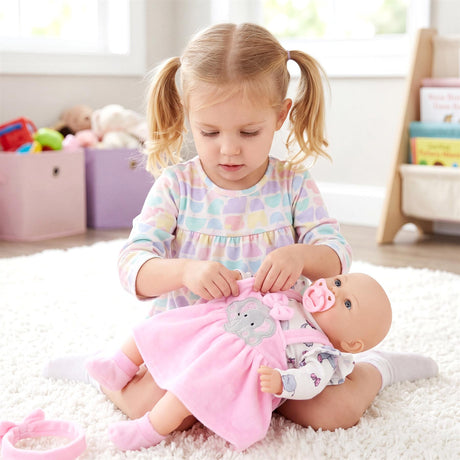 Girl dresses doll: a large doll in a pink dress and striped outfit.