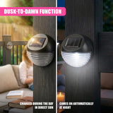 Black solar fence lights with solar panels are mounted on two vertical wood posts.