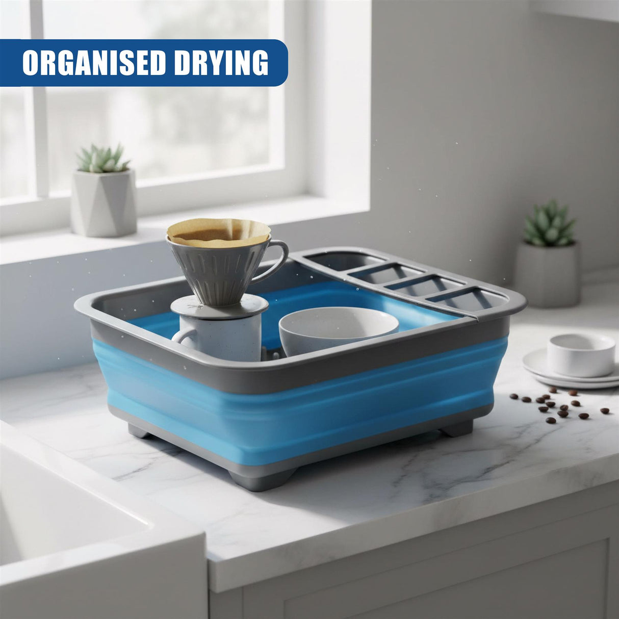 A blue and gray collapsible dish drainer with sections holding a cup and a small bowl sits on a counter.
